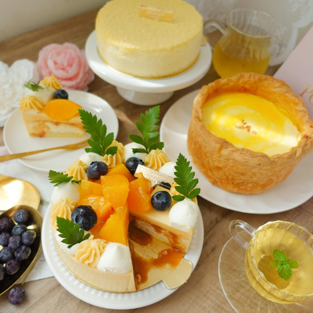 A delectable spread of cakes and desserts garnished with fresh fruits and accompanied by tea.