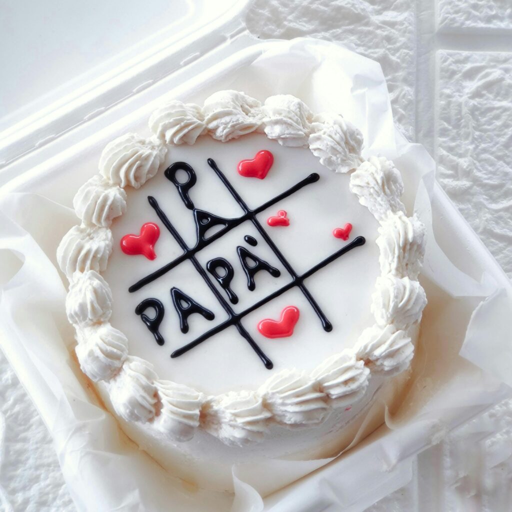 White cake for Father's Day with icing hearts and 'Papa' text.