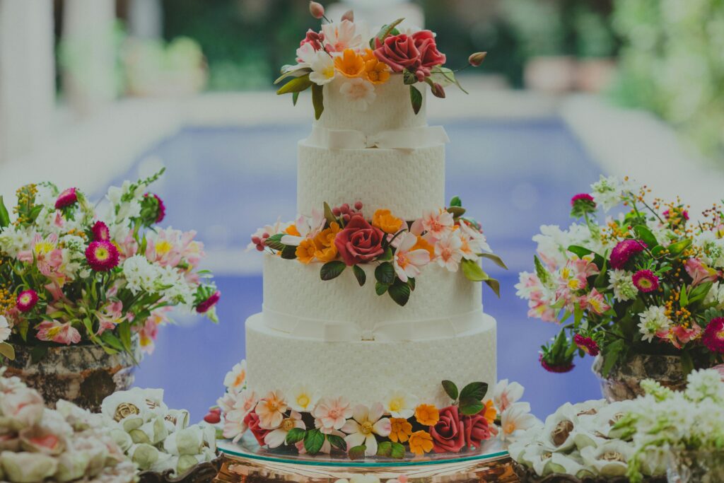 Three-tier wedding cake adorned with colorful flowers, perfect for elegant celebrations.